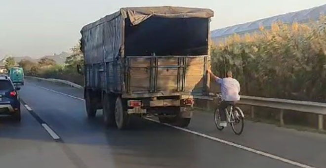 Hızla giden kamyonun arkasına tutunan bisikletli yürekleri ağza getirdi 